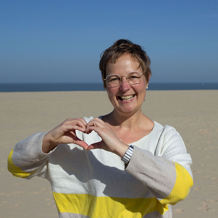 Halbportrait: Herz mit Händen formend, Freizeit am Strand am Meer mit blauem Himmel