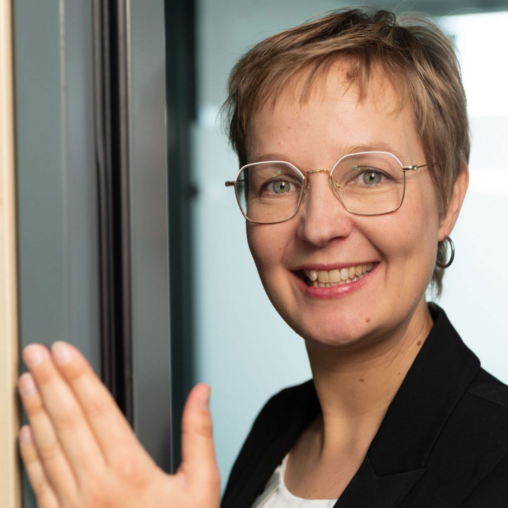 Sandra Kroning Business Portrait an Türrahmen im Büro